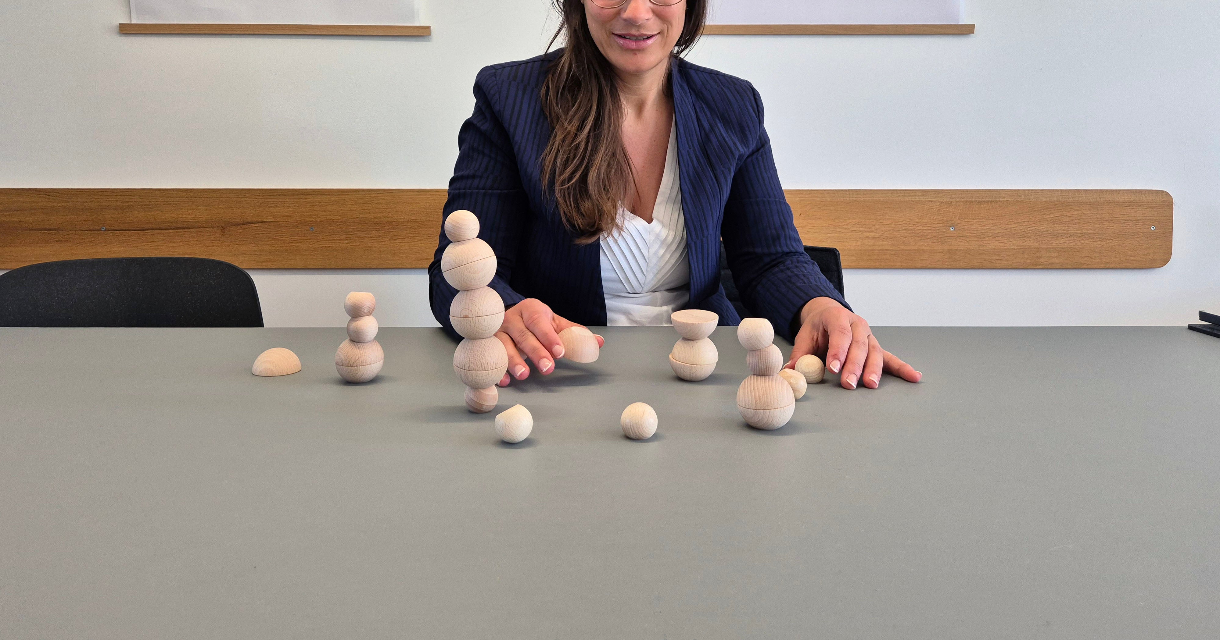 Erwachsene Frau spielt Ballance Stapelspiel zur Konzentration im Büro oder Workshop